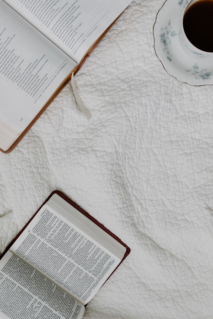 Person comparing two open Bibles side by side during study