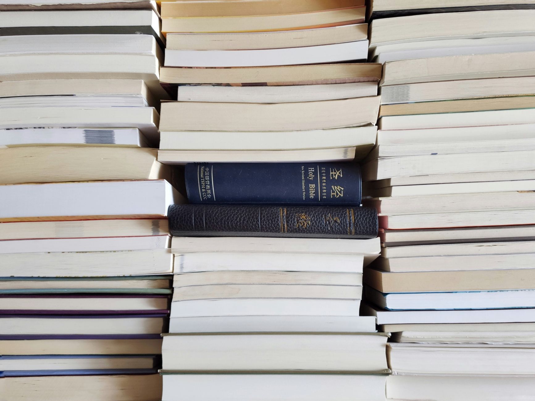 A stack of study guides beside an open Bible
