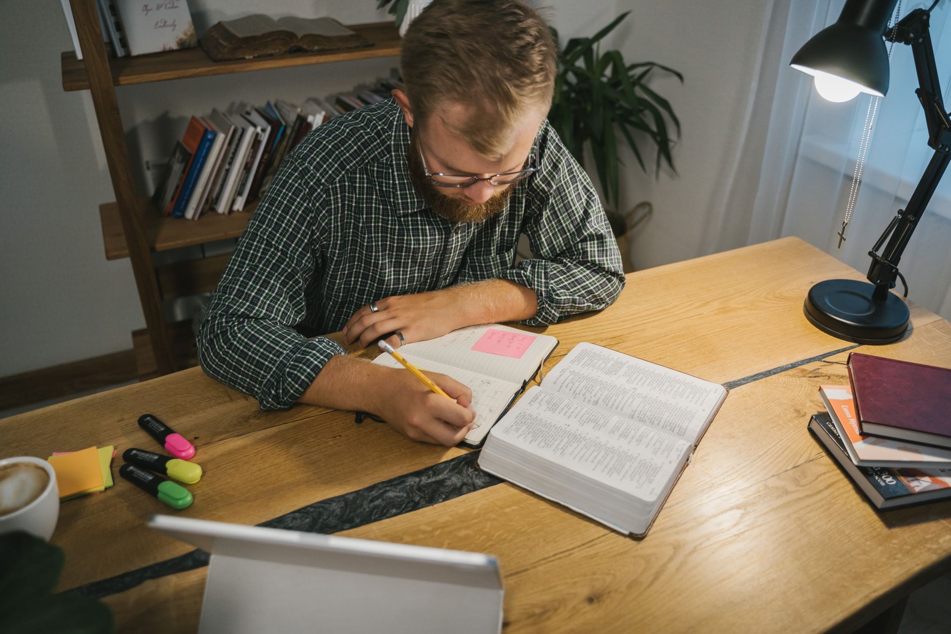 An open Bible with handwritten study notes and a highlighter