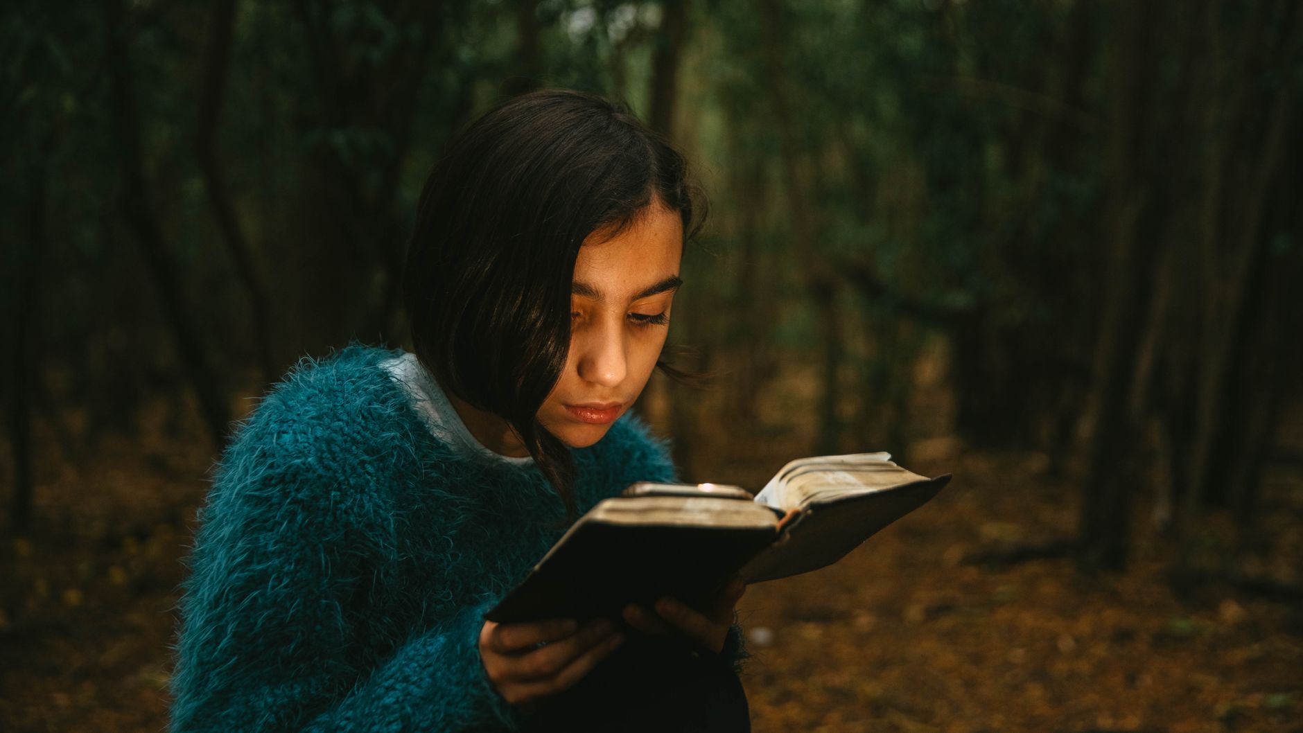 A woman reading her Bible in soft natural light